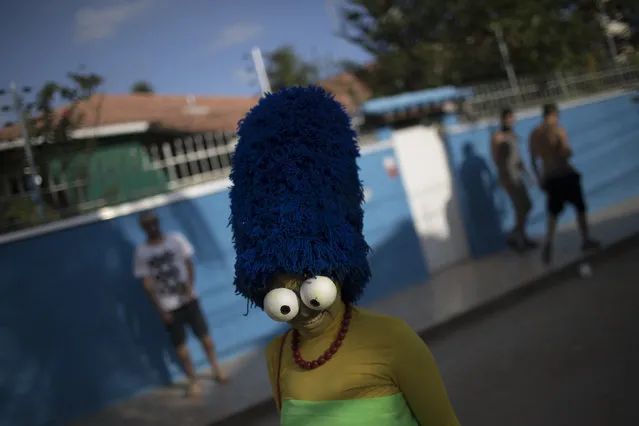 A reveler poses for a picture during the Perola da Guanabara street party at the Paqueta island in the Guanabara bay in Rio de Janeiro, Brazil, Saturday, February 3, 2018. Merrymakers take to the streets in hundreds of open-air “bloco” parties ahead of Rio's over-the-top Carnival, the highlight of the year for many. (Photo by Leo Correa/AP Photo)