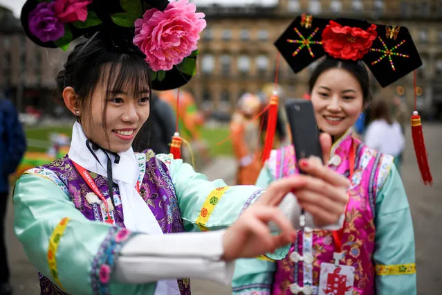 Women take selfie photos as the Chinese community in Glasgow celebrate during Lunar New Year celebrations for the Year of the Dog at Glasgow City Chambers on February 18, 2018 in Glasgow. The Chinese Lunar New Year also known as the Spring Festival, which is based on the Lunisolar Chinese calendar, is celebrated from the first day of the first month of the lunar year and ends with Lantern Festival on the fifteenth day. (Photo by Jeff J. Mitchell/Getty Images)