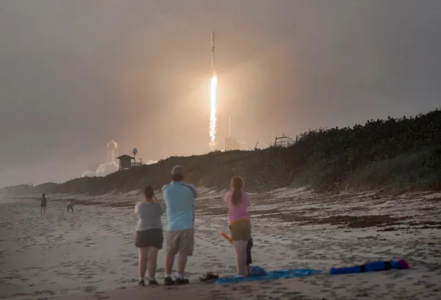 Spectators watch from Canaveral National Seashore as a SpaceX Falcon 9 rocket carrying 60 Starlink satellites launches from pad 39A at the Kennedy Space Center on October 6, 2020 in Cape Canaveral, Florida. This is the 13th batch of satellites placed into orbit by SpaceX as part of a constellation designed to provide broadband internet service around the globe. (Photo by Paul Hennessy/NurPhoto via Getty Images)