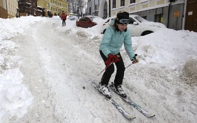 The girl rides mountain skiing on the street of Kiev, Ukraine, on March 24, 2013. In Ukraine the record quantity of snow dropped out. (Photo by Sergei Chuzavkov/AP Photo)