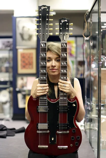 Claire Tole-Moir of Bonhams posing with a Gibson signature Vintage Original EDS-1275 Doubleneck guitar – a custom model which was made to the same specifications as Jimmy Page's classic original doubleneck guitar – during a photocall for highlights of Bonhams' forthcoming Entertainment Memorabilia Sale in Knightsbridge, London, December 5, 2014. (Photo by Yui Mok/PA Wire)