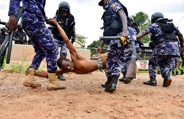 Ugandan riot policemen detain a supporter of presidential candidate Robert Kyagulanyi, also known as Bobi Wine, in Luuka district, eastern Uganda on November 18, 2020. (Photo by Abubaker Lubowa/Reuters)