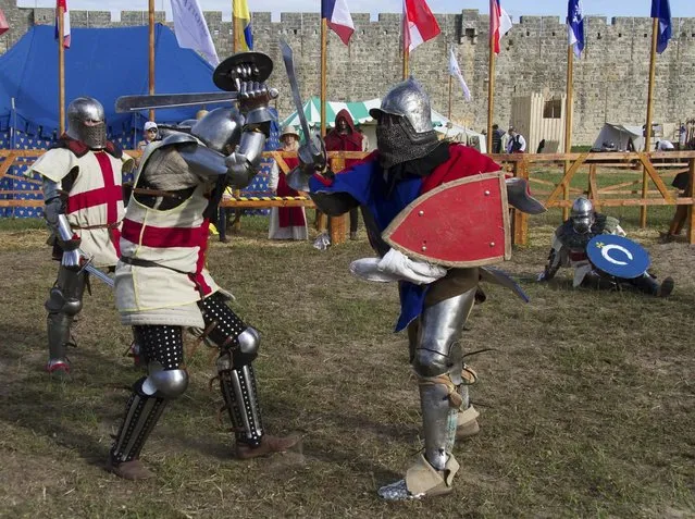 Members of the  UK team, left, fight against a Czech Republic contestant during the “Battle of Nations” in Aigues-Mortes, southern France, Friday, May 10, 2013 where Middle Ages fans attend the historical medieval battle competition. The championship will be attended by 22 national teams, which is twice the number it was last year. The battle lasts until May 12.(Photo by Philippe Farjon/AP Photo)