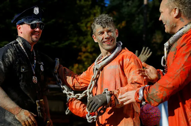 Competitors in costumes smile after finishing the Wildsau Dirt Run (Wild Boar Dirt Run) obstacle course fun race at Hellsklamm ravine in Obertriesting, Austria, October 22, 2016. (Photo by Heinz-Peter Bader/Reuters)
