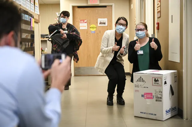 From right, Hayley Kytta and Tam Nguyen, both 4th year pharmacy students at the University of Minnesota, pose for a photo with a box containing 975 doses of the Pfizer-BioNTech vaccine for COVID-19 which just arrived at North Memorial Health Hospital Tuesday, December 15, 2020 in Robbinsdale, Minn. (Photo by Aaron Lavinsky/Star Tribune via AP Photo/Pool)