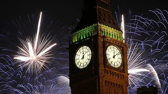 Fireworks explode behind the Houses of Parliament and Big Ben on the River Thames during New Year celebrations in London January 1, 2015. (Photo by Suzanne Plunkett/Reuters)