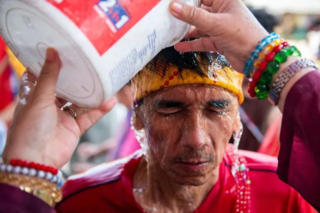 15 Mysteries Catholic Lay Missionaries founder Sister Jovita Domingo pours water to a devotee during a ritual on Good Friday, in San Miguel, Bulacan province, Philippines, April 7, 2023. (Photo by Lisa Marie David/Reuters)