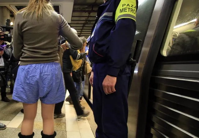 A participant stands next to a subway guard during “The No Pants Subway Ride” in Bucharest January 11, 2015. (Photo by Radu Sigheti/Reuters)