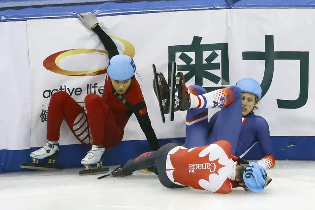 Chen Guang (L) of China, Sebastien Lepape of France and Francois Hamelin (front) of Canada crash into the barrier while competing in the men's 1500m final during the ISU World Cup Short Track Speed Skating competition in Shanghai, China, December 12, 2015. (Photo by Aly Song/Reuters)