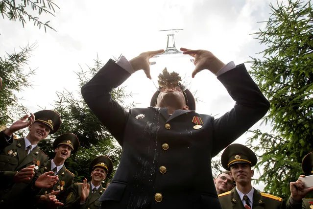 Graduates drink champagne as they celebrate after receiving diplomas at the Military Academy of Belarus in Minsk, Belarus, June 30, 2018. (Photo by Vasily Fedosenko/Reuters)