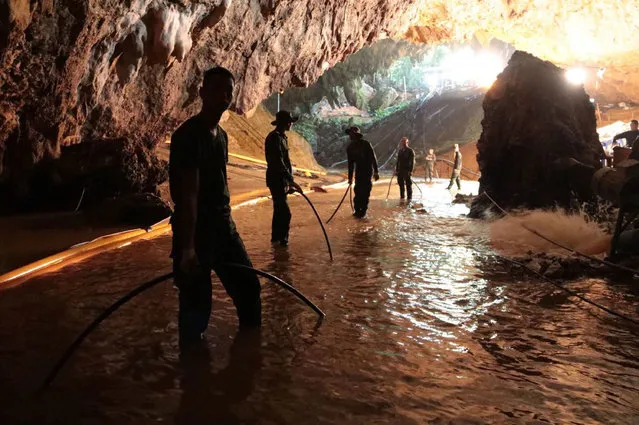 In this undated photo released by Royal Thai Navy on Saturday, July 7, 2018, Thai rescue teams arrange water pumping system at the entrance to a flooded cave complex where 12 boys and their soccer coach have been trapped since June 23, in Mae Sai, Chiang Rai province, northern Thailand. The local governor in charge of the mission to rescue them said Saturday that cooperating weather and falling water levels over the last few days had created appropriate conditions for evacuation, but that they won't last if it rains again.. (Photo by Royal Thai Navy via AP Photo)