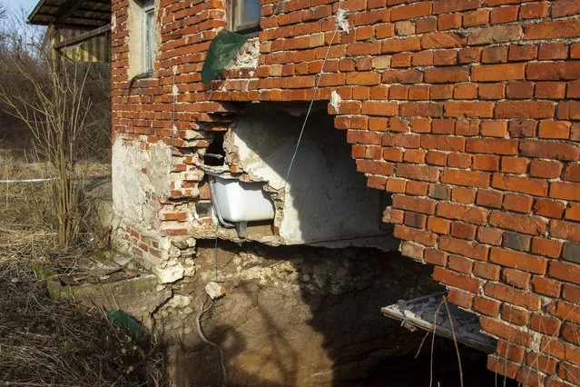 This photo shows a sinkhole under a house in the village of Mececani, central Croatia, Thursday, March 4, 2021. A central Croatian region about 40 kilometers (25 miles) southwest of the capital Zagreb is pocked with round holes of all sizes, which appeared after December's 6.4-magnitude quake that killed seven people and caused widespread destruction. Scientists have been flocking to Mecencani and other villages in the sparsely-inhabited region for observation and study. (Photo by Darko Bandic/AP Photo)