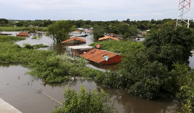 Houses are seen partially submerged in floodwaters in Asuncion, December 27, 2015. (Photo by Jorge Adorno/Reuters)