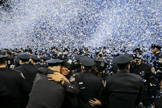 Newly inducted New York Police hug as they take part in a graduation ceremony at Madison Square Garden in the Manhattan borough of New York December 29, 2015. According to New York's Mayor Bill de Blasio, 1123 new officers graduated onto the force. (Photo by Carlo Allegri/Reuters)