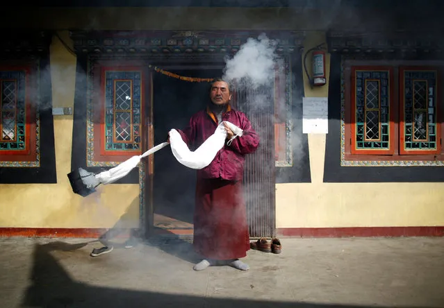 A monk swings an incense burner during the prayers to purify the Boudhanath stupa ahead of its opening on November 22, after it was renovated following last year's earthquake in Kathmandu, Nepal November 18, 2016. (Photo by Navesh Chitrakar/Reuters)