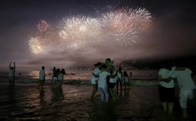 People watch as fireworks explode over Copacabana beach during New Year celebrations in Rio de Janeiro, Brazil, January 1, 2016. (Photo by Lunae Parracho/Reuters)