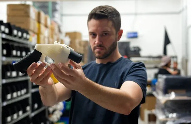 Cody Wilson, owner of Defense Distributed company, holds a 3D printed gun, called the “Liberator”, in his factory in Austin, Texas on August 1, 2018. The US “crypto-anarchist” who caused panic this week by publishing online blueprints for 3D-printed firearms said Wednesday that whatever the outcome of a legal battle, he has already succeeded in his political goal of spreading the designs far and wide. A federal court judge blocked Texan Cody Wilson's website on Tuesday, July 31, 2018, by issuing a temporary injunction. (Photo by Kelly West/AFP Photo)