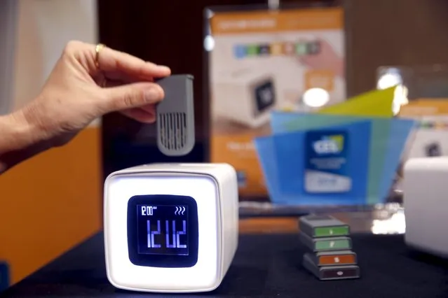 An aroma module is inserted into a Sensorwake alarm clock during "CES Unveiled," a preview event of the 2016 International CES trade show, in Las Vegas, Nevada January 4, 2016. The $109 olfactory alarm clock releases the scents at the programmed time but will also sound an auditory alarm if you don't wake up after three minutes. (Photo by Steve Marcus/Reuters)