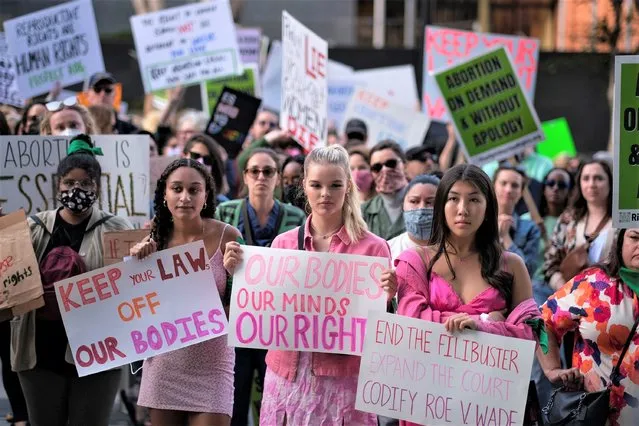 Demonstrators holding signs protest outside of the U.S. Courthouse in response to leaked draft of the Supreme Court's opinion to overturn Roe v. Wade, in Los Angeles, Tuesday, March 3, 2022. (Photo by Ringo H.W. Chiu/AP Photo)