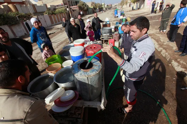 Iraqi people collect water in Mosul, Iraq, December 3, 2016. (Photo by Alaa Al-Marjani/Reuters)
