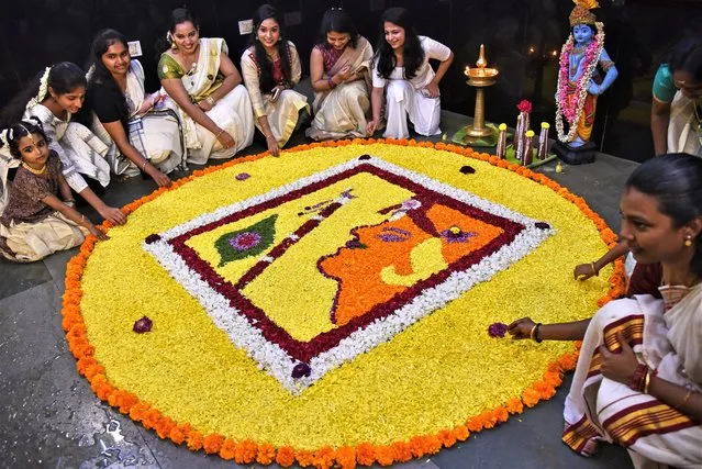 Malayali community members prepare a flower carpet or “Pookalam” as they celebrate the Onam festival, at Sree Ayyappan Guruvayurappan temple, in Chennai, India, 29 August 2023. The Onam festival is a 10-day long harvest festival and is celebrated mostly in India's southern state of Kerala. Malayalam people in India and across the world put decorated flower beds in front of their houses to welcome King Mahabali, a past ruler of Kerala in southern India. (Photo by Idrees Mohammed/EPA)