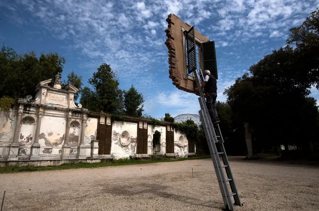 A worker works on an installation entitled “Window and Ladder – Citta eterna 2021” by Argentine artist Leandro Erlich prior to the opening of the exhibition “Back to Nature” at Villa Borghese park in Rome on May 11, 2021. (Photo by Tiziana Fabi/AFP Photo)