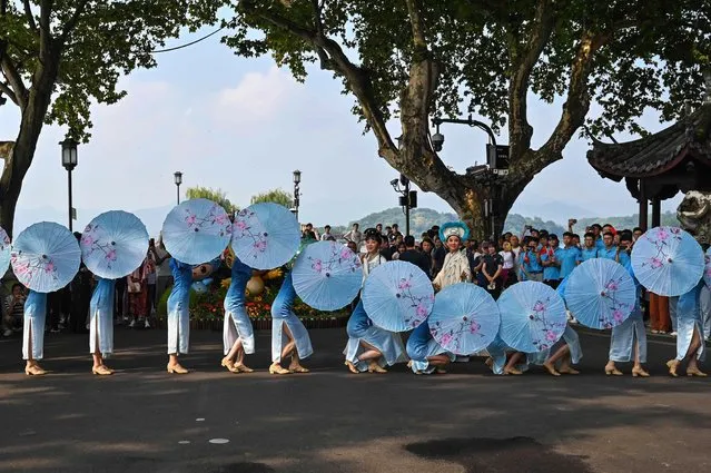 Performers take part in a performance before the start of the Asian Games torch relay in Hangzhou, in China's eastern Zhejiang province on September 8, 2023. (Photo by Hector Retamal/AFP Photo)