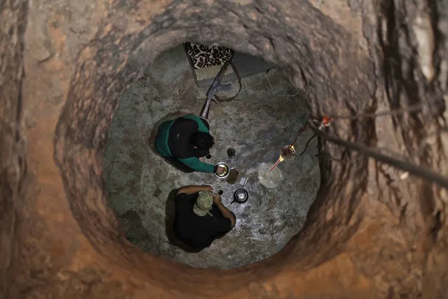 Syrian rebel-fighters with the National Liberation Front (NLF) are seen through a hole siting in a covered structure in the northwestern countryside of Aleppo province on October 9, 2018. Jihadists and Turkish-backed rebels in Syria's last major opposition stronghold have withdrawn heavy weapons from nearly all of a planned buffer zone, a monitor said today, a day ahead of deadline. (Photo by Aaref Watad/AFP Photo)