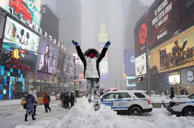 Bella Fraker, 10, of Atlanta, stands high on a snow pile as she poses for a family photo in New York's Times Square Saturday, January 23, 2016, as a large winter storm rolls up the East Coast. Fraker was in New York for auditions. (Photo by Craig Ruttle/AP Photo)