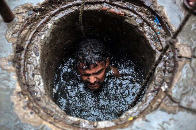 Joney, a 26 year-old sewer worker cleans a sewer line in Ghaziabad, Uttar Pradesh, India, 26 July 2018. Joney along with other sewer workers cleans the sewer lines by going inside the pits in Ghaziabad area without any safety masks or any safety equipment except for a safety belt to lift them up. Recent official government statistics showed one manual scavengers has died every five days since the beginning of 2017 while cleaning sewers. This is one of the most dangerous jobs in India and its usually done by the Valmiki community, a sub-caste that is considered one of the lowest of the so-called “untouchable” or Dalit caste. Members of these communities have traditionally occupied cleaning and sanitation work in Indian society. (Photo by Rajat Gupta/EPA/EFE)