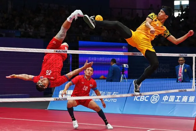 Thailand's Pichet Pansan (L) kicks the ball as Malaysia's Muhammad Noraizat Mohd Nordin (R) defends in the final match of the men's team sepak takraw during the Hangzhou 2022 Asian Games, in Jinhua, in China's eastern Zhejiang province on September 29, 2023. (Photo by Hector Retamal/AFP Photo)
