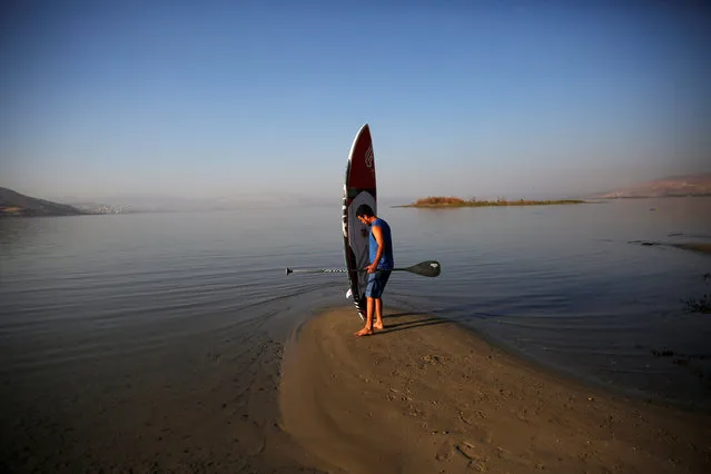 Yotam Steinberg from Kibbutz Maagan holds his stand-up paddle board as he enters the Sea of Galilee, northern Israel November 8, 2016. (Photo by Ronen Zvulun/Reuters)