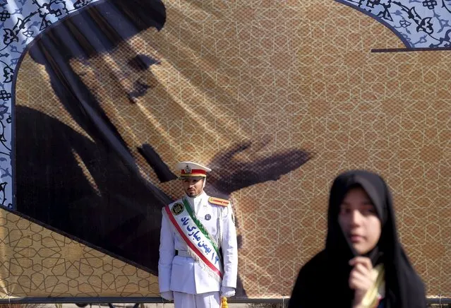An Iranian soldier stands guard in front of a picture of Iran's late leader Ayatollah Ruhollah Khomeini during the anniversary ceremony of Iran's Islamic Revolution in Behesht Zahra cemetery, south of Tehran, February 1, 2016. (Photo by Raheb Homavandi/Reuters/TIMA)