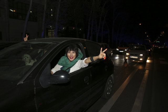 An Iranian woman flashes a victory sign from her car while celebrating on a street in northern Tehran, Iran, Thursday, April 2, 2015, after Iran's nuclear agreement with world powers in Lausanne, Switzerland. (Photo by Vahid Salemi/AP Photo)