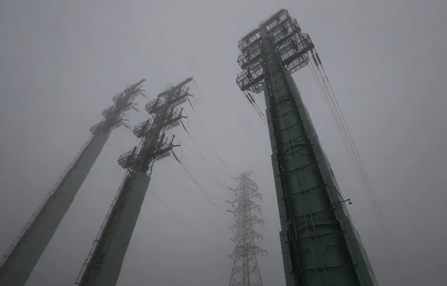Transmission towers supplying power to the Kaesong Industrial Complex from South Korea are seen on a foggy and rainy day after South Korea cut off power, in Paju, South Korea, February 12, 2016. South Korea has cut off power and water supplies to a factory park in North Korea, officials said Friday, a day after the North deported all South Korean workers there and ordered a military takeover of the complex that had been the last major symbol of cooperation between the rivals. (Photo by Lee Jin-man/AP Photo)