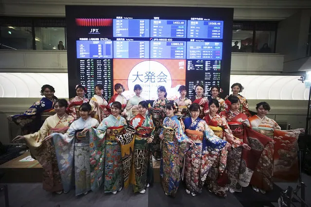Kimono-clad employees of the Tokyo Stock Exchange and models pose for photographers in front of stock price boards after a ceremony marking the start of this year's trading in Tokyo Friday, January 4, 2019. (Photo by Eugene Hoshiko/AP Photo)