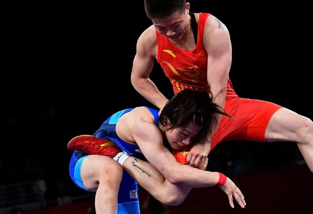 China's Pang Qianyu (red) wrestles Japan's Mayu Mukaida in their women's freestyle 53kg wrestling final match during the Tokyo 2020 Olympic Games at the Makuhari Messe in Tokyo on August 6, 2021. (Photo by Piroschka van de Wouw/Reuters)