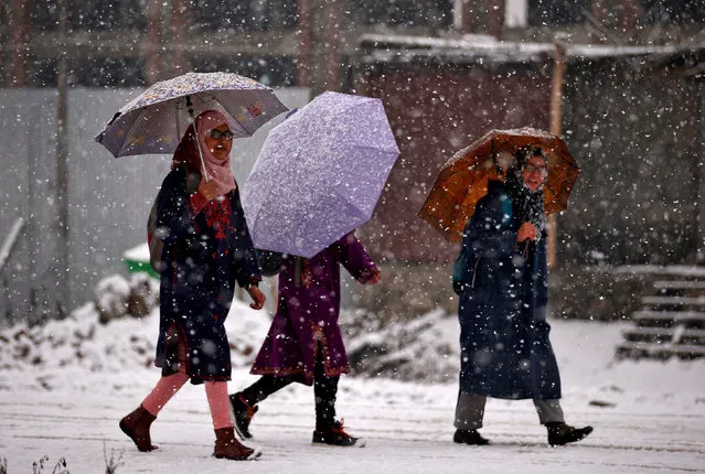 Women walk with umbrellas during a snowfall on a cold winter morning in Srinagar, January 5, 2017. (Photo by Danish Ismail/Reuters)