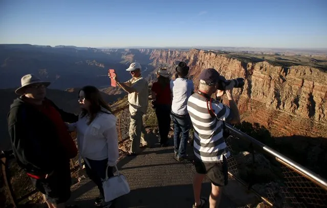 People take photos as the sun sets at the Grand Canyon National Park in northern Arizona, April 13, 2015. (Photo by Jim Urquhart/Reuters)