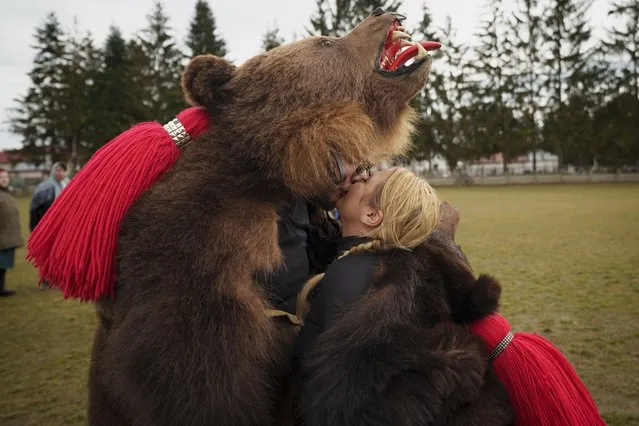 Members of the Sipoteni bear pack kiss after perform a ritual dance in Racova, northern Romania, Tuesday, December 26, 2023. Centuries ago, people in what is now northeastern Romania would don bear fur and dance to fend off evil spirits. Nowadays, the unique custom thrives, with popular festivals drawing large crowds of locals and tourists. (Photo by Andreea AlexandruAP Photo)
