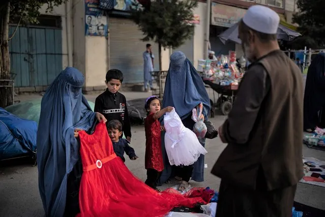 Afghan women and a girl shop for dresses at a local market in Kabul, Afghanistan, Friday, September 10, 2021. (Photo by Felipe Dana/AP Photo)