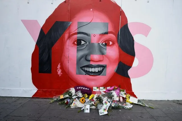 Flowers are left at the foot of a new mural of Savita Halappanavar put up on the day of the abortion referendum that repealed Ireland's strict abortion laws in Dublin, Ireland May 25, 2018. Hundreds of people left flowers and candles at a large mural of Halappanavar, the 31-year-old Indian whose death in 2012 from a septic miscarriage after being refused a termination spurred lawmakers into action. (Photo by Clodagh Kilcoyne/Reuters)