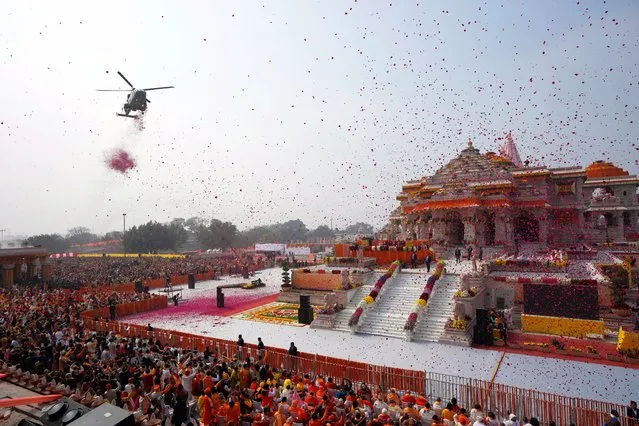 An Indian Air Force helicopter showers flower petals during the opening of a temple dedicated to Hinduism’s Lord Ram in Ayodhya, India, Monday, January 22, 2024. Indian Prime Minister Narendra Modi opened the controversial Hindu temple built on the ruins of a historic mosque in the holy city of Ayodhya in a grand event that is expected to galvanize Hindu voters in upcoming elections. (Photo by Rajesh Kumar Singh/AP Photo)