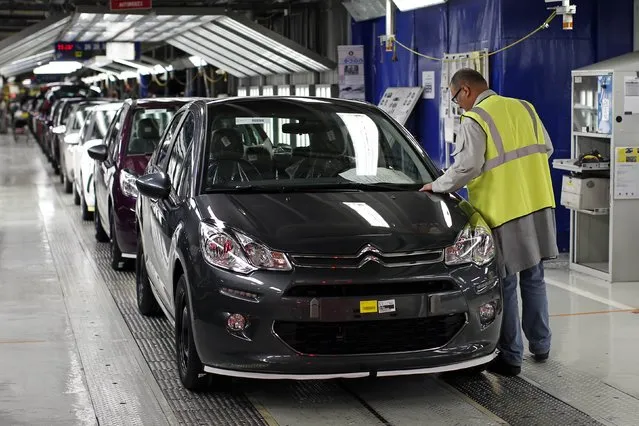 A worker looks at a Citroen C3 car in the final check area at the PSA Peugeot Citroen plant in Poissy, near Paris, April 29, 2015. PSA Peugeot Citroen said on Wednesday its revenue rose in the first quarter as the recovering French carmaker's efforts to raise prices helped offset weaker volumes. (Photo by Benoit Tessier/Reuters)