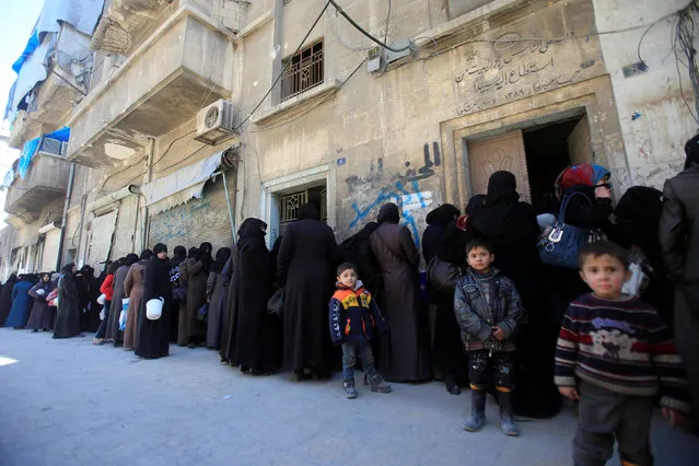 Women and children queue to receive free meals in Aleppo, Syria February 2, 2017. (Photo by Ali Hashisho/Reuters)