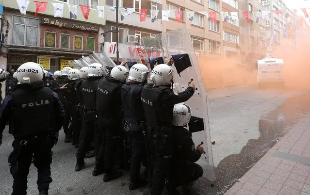 Turkish riot police officers hold their positions during clashes with demonstrators in Istanbul, Turkey, Friday, May 1, 2015. Clashes erupted between police and May Day demonstrators in Istanbul on Friday as crowds determined to defy a government ban tried to march to the city's iconic Taksim Square. Security forces pushed back demonstrators with a water cannon and tear gas. (Photo by Emrah Gurel/AP Photo)