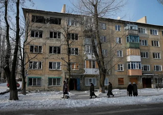 A local resident walk near a building which was damaged during fighting between the Ukrainian army and pro-Russian separatists, in the government-held industrial town of Avdiyivka, Ukraine, February 3, 2017. (Photo by Gleb Garanich/Reuters)