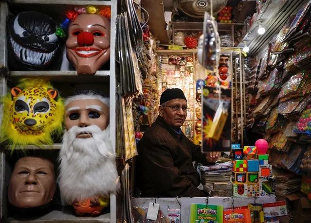 A shopkeeper sits inside a shop as a mask of former Prime Minister Imran Khan is displayed alongside other masks a day ahead of the general election in Lahore, Pakistan, on February 7, 2024. (Photo by Navesh Chitrakar/Reuters)