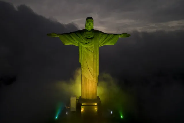 Christ the Redeemer statue is illuminated in the colors of the Brazilian national flag to honor late soccer legend Pele, in Rio de Janeiro, Brazil, Thursday, December 29, 2022, Edson Arantes do Nascimento, known as Pele has died in Sao Paulo. He was 82. (Photo by Bruna Prado/AP Photo)