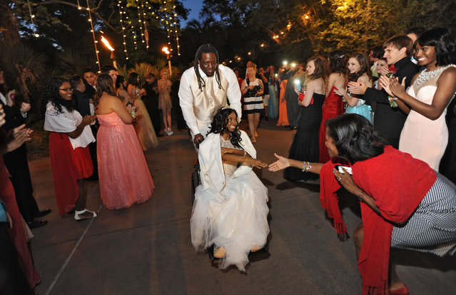 NFL Jacksonville Jaguars defensive tackle Sen'Derrick Marks escorts 18-year-old cancer patient Khameyea Jennings to her senior prom at the Jacksonville Zoo and Gardens, through the Dreams Come True program, Saturday, May 2, 2015, in Jacksonville, Fla. They were greeted by students from the school and her Social Studies, Economics and Government teacher. (Photo by Bob Mack/The Florida Times-Union via AP Photo)